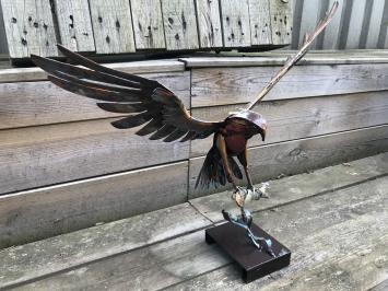 Een metalen kunstwerk van een adelaar die een vis vangt, 'IRON EAGLE'