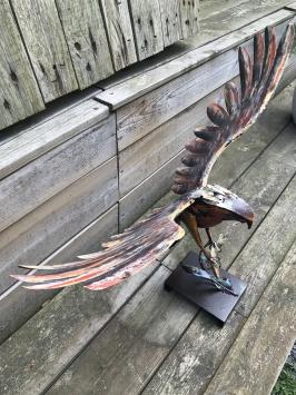 Een metalen kunstwerk van een adelaar die een vis vangt, 'IRON EAGLE'