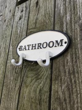 Kapstok met 2 haken, bord met opschrift: 'BATHROOM', gietijzer