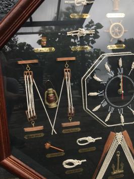 Ausstellung von maritimen Knoten in einer Vitrine, mit einer Uhr darin