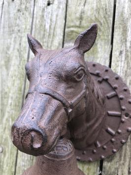 Deurbel met paardenhoofd gevestigd op een fraaie achtergrond