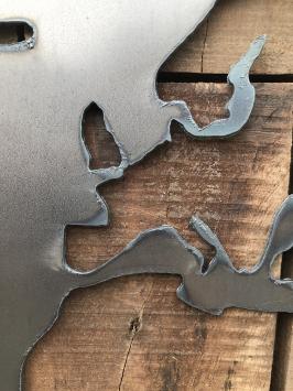 Großes Wandornament aus Holz mit einer Welt darauf, ein Meer aus Metall